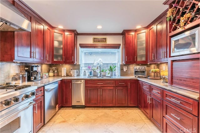 13837 Sylvan St, Valley Glen, CA 91401 - kitchen with wall chimney exhaust hood, dark brown cabinets, appliances with stainless steel finishes, decorative backsplash, and recessed lighting