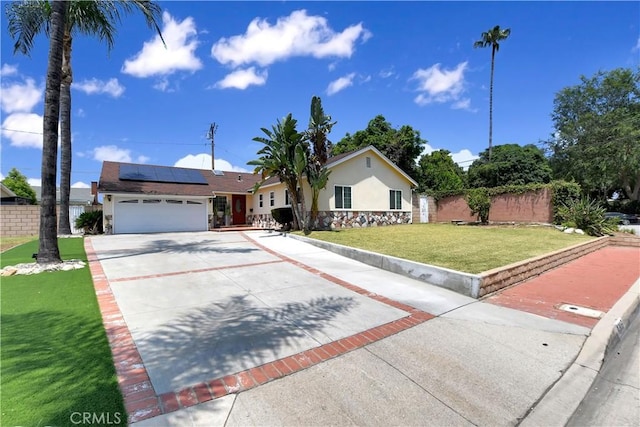 1305 E Eckerman Ave, West Covina, CA 91790 - ranch-style home featuring an attached garage, solar panels, concrete driveway, and stucco siding