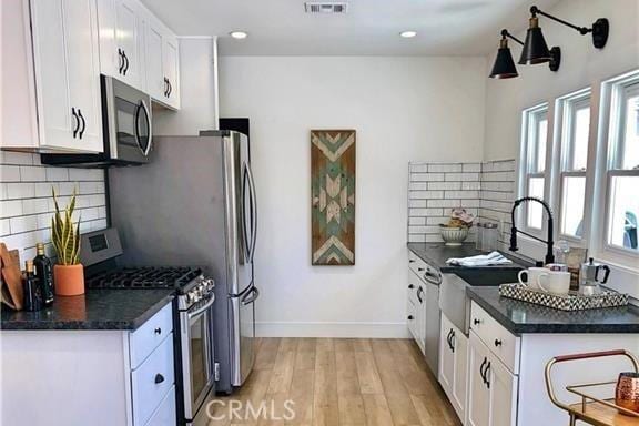 341 W Whiting Ave, Fullerton, CA 92832 - kitchen with gas range, dark countertops, white cabinets, light wood-style flooring, and recessed lighting