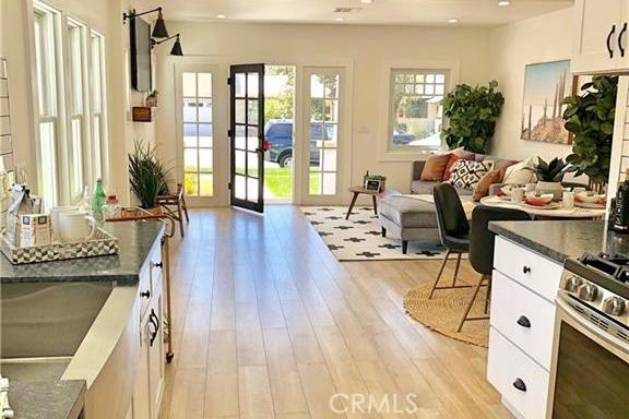 341 W Whiting Ave, Fullerton, CA 92832 - interior space featuring light wood finished floors, white cabinetry, french doors, stainless steel gas stove, and open floor plan