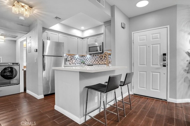 6323 Reseda Blvd Unit 39, Tarzana, CA 91335 - kitchen featuring appliances with stainless steel finishes, washer / dryer, dark wood-type flooring, light countertops, and recessed lighting