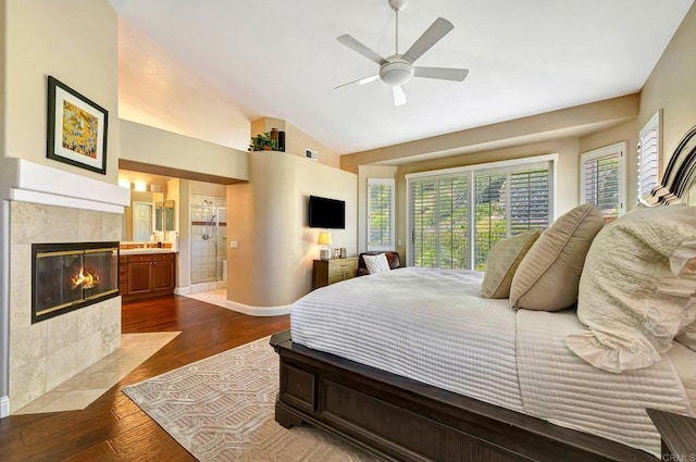 282 Camino Del Postigo, Escondido, CA 92029 - bedroom with dark wood-style flooring, lofted ceiling, a tile fireplace, connected bathroom, and a ceiling fan