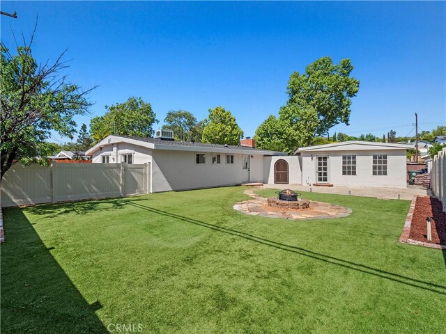 27545 Santa Clarita Rd, Saugus, CA 91350 - back of house featuring a fenced backyard, an outdoor fire pit, stucco siding, and a patio area