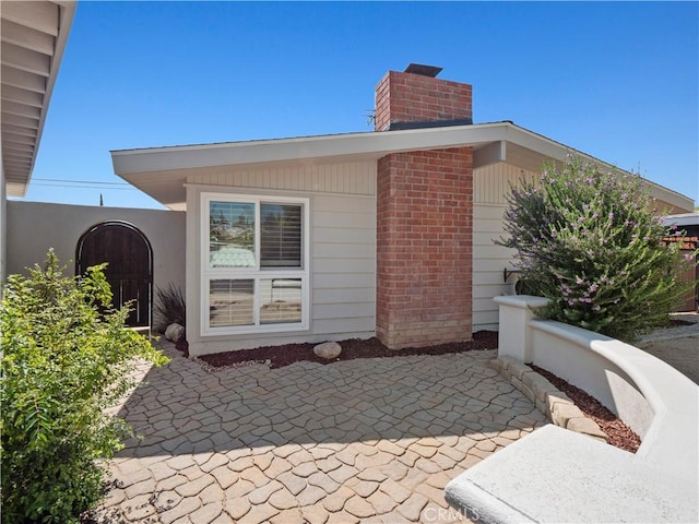 27545 Santa Clarita Rd, Saugus, CA 91350 - view of side of home featuring a chimney and a patio area