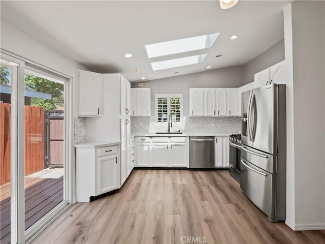 27545 Santa Clarita Rd, Saugus, CA 91350 - kitchen with appliances with stainless steel finishes, a skylight, tasteful backsplash, light countertops, and light wood-style flooring