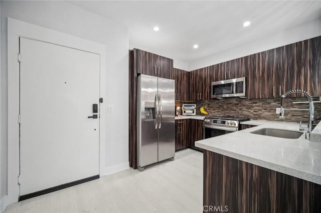 24545 Town Center Dr Unit 5405, Valencia, CA 91355 - kitchen featuring appliances with stainless steel finishes, light stone countertops, tasteful backsplash, light wood finished floors, and modern cabinets