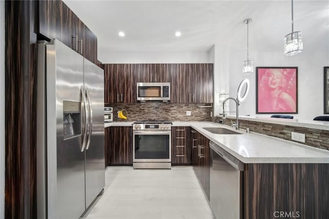 24545 Town Center Dr Unit 5405, Valencia, CA 91355 - kitchen with appliances with stainless steel finishes, modern cabinets, a peninsula, light countertops, and dark brown cabinetry