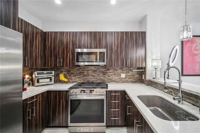 24545 Town Center Dr Unit 5405, Valencia, CA 91355 - kitchen featuring appliances with stainless steel finishes, modern cabinets, dark brown cabinetry, backsplash, and pendant lighting
