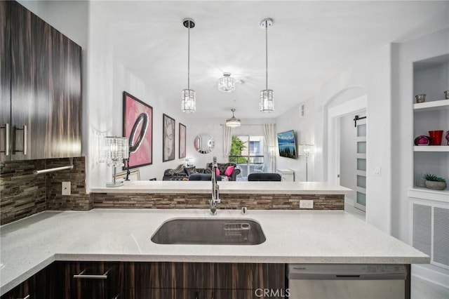 24545 Town Center Dr Unit 5405, Valencia, CA 91355 - kitchen featuring stainless steel dishwasher, backsplash, open floor plan, hanging light fixtures, and light stone countertops