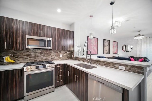 24545 Town Center Dr Unit 5405, Valencia, CA 91355 - kitchen with stainless steel appliances, a peninsula, light countertops, tasteful backsplash, and dark brown cabinets