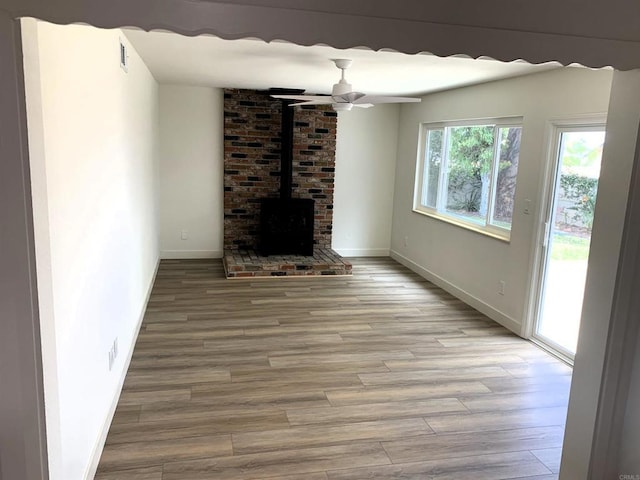 1878 Wolviston Way, San Diego, CA 92154 - unfurnished living room with a wood stove, light wood-style flooring, and a ceiling fan