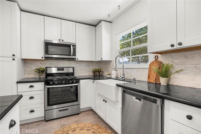 17139 Strathern St, Van Nuys, CA 91406 - kitchen with stainless steel appliances, dark countertops, white cabinets, and backsplash