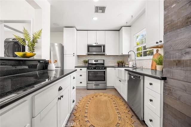 17139 Strathern St, Van Nuys, CA 91406 - kitchen featuring stainless steel appliances, backsplash, white cabinets, dark stone countertops, and recessed lighting