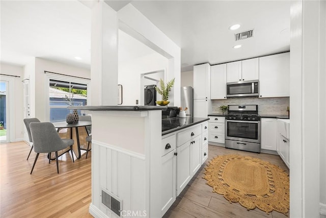 17139 Strathern St, Van Nuys, CA 91406 - kitchen with stainless steel appliances, dark countertops, light wood-style flooring, tasteful backsplash, and recessed lighting