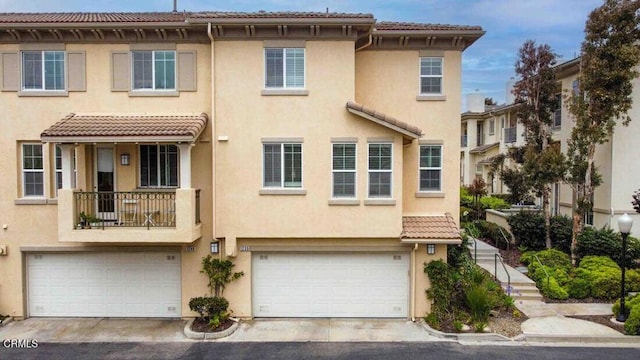 1239 Bayside Ln, Oxnard, CA 93035 - townhome / multi-family property with stucco siding, an attached garage, a tiled roof, and concrete driveway