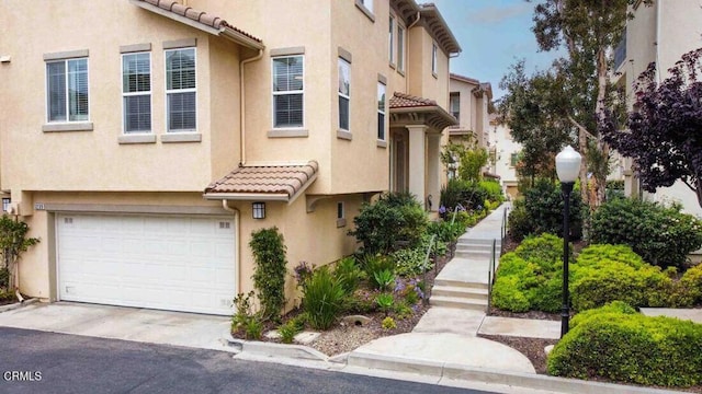 1239 Bayside Ln, Oxnard, CA 93035 - view of front of property featuring a tiled roof, a garage, stucco siding, and driveway