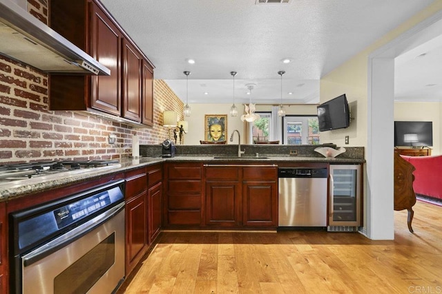 301 W G St Unit 119, San Diego, CA 92101 - kitchen with appliances with stainless steel finishes, wine cooler, wall chimney exhaust hood, light wood-style floors, and recessed lighting