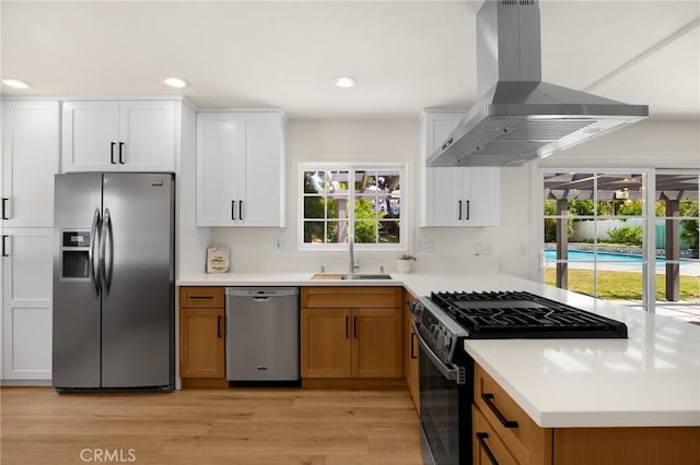 1345 W Valley View Dr, Fullerton, CA 92833 - kitchen with stainless steel appliances, island exhaust hood, light wood-type flooring, light countertops, and white cabinets