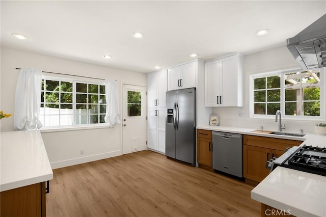 1345 W Valley View Dr, Fullerton, CA 92833 - kitchen with stainless steel appliances, wall chimney exhaust hood, plenty of natural light, light wood-style floors, and recessed lighting