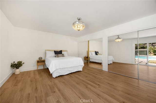 1345 W Valley View Dr, Fullerton, CA 92833 - bedroom featuring multiple closets, access to exterior, light wood-style floors, and a chandelier