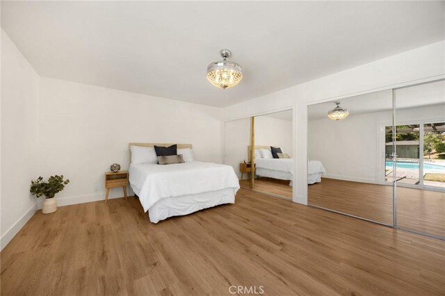 1345 W Valley View Dr, Fullerton, CA 92833 - bedroom with multiple closets, access to outside, light wood finished floors, and a chandelier