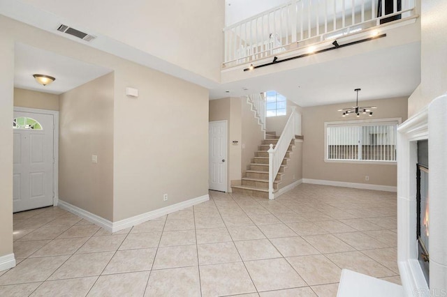 15140 Chase St, North Hills, CA 91343 - unfurnished living room featuring a chandelier, stairs, light tile patterned floors, and a high ceiling