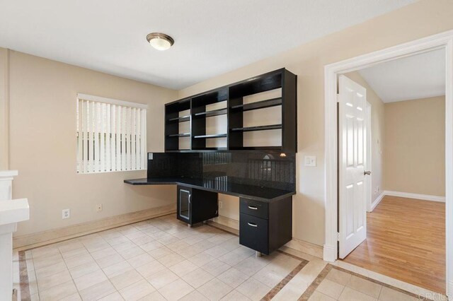 15140 Chase St, North Hills, CA 91343 - unfurnished office featuring light tile patterned floors, built in desk, inlaid floor details, and plenty of natural light