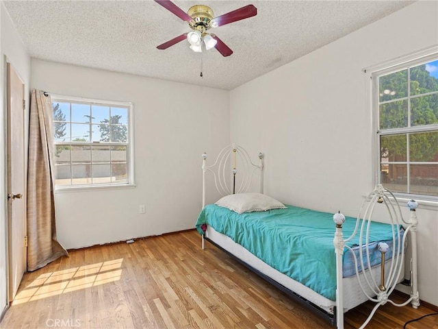 2724 Scott Rd, Burbank, CA 91504 - bedroom featuring multiple windows, a textured ceiling, light wood finished floors, and a ceiling fan