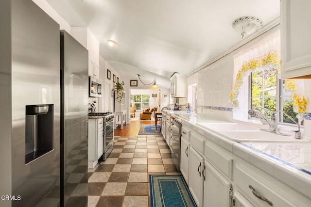 216 N Fulton St, Ojai, CA 93023 - kitchen featuring appliances with stainless steel finishes, white cabinetry, and vaulted ceiling
