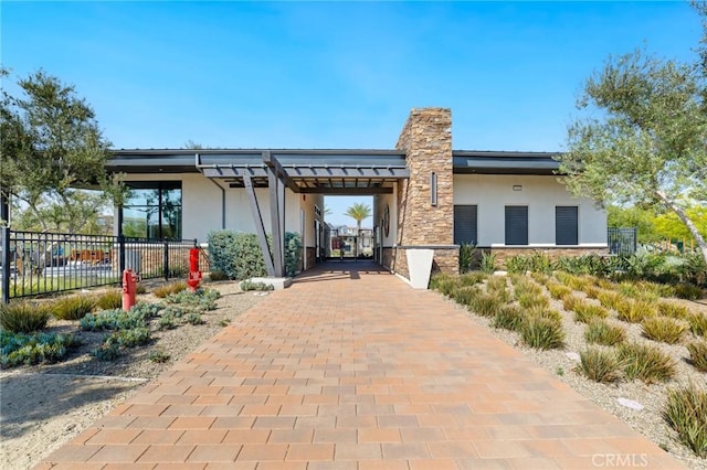 16502 Casa Grande Ave Unit 318, Fontana, CA 92336 - rear view of house featuring stucco siding, a chimney, and stone siding