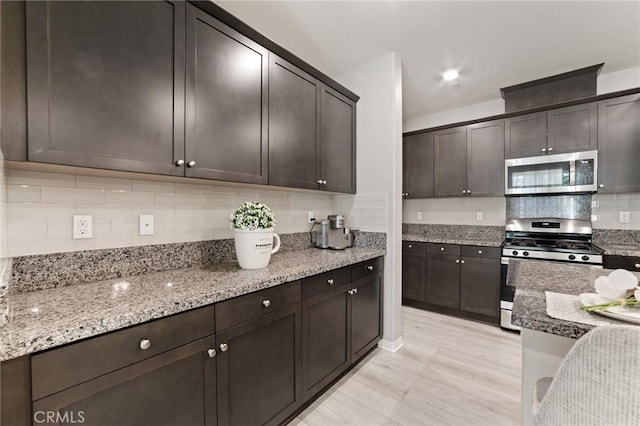 16502 Casa Grande Ave Unit 318, Fontana, CA 92336 - kitchen with stainless steel appliances, tasteful backsplash, light wood finished floors, light stone countertops, and dark brown cabinets