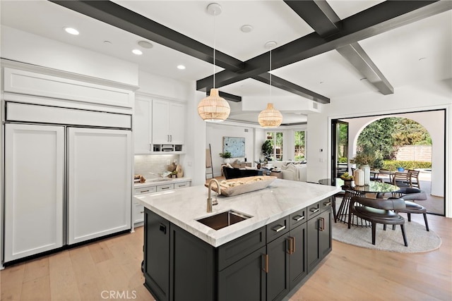 6 Rickie, Ladera Ranch, CA 92694 - kitchen with paneled built in refrigerator, white cabinets, light wood-type flooring, tasteful backsplash, and pendant lighting