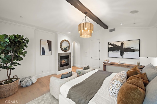 6 Rickie, Ladera Ranch, CA 92694 - bedroom featuring arched walkways, wood finished floors, a chandelier, crown molding, and a glass covered fireplace