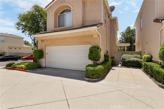 27861 Crown Court Cir Unit 72, Valencia, CA 91354 - view of front of property featuring an attached garage, driveway, and stucco siding