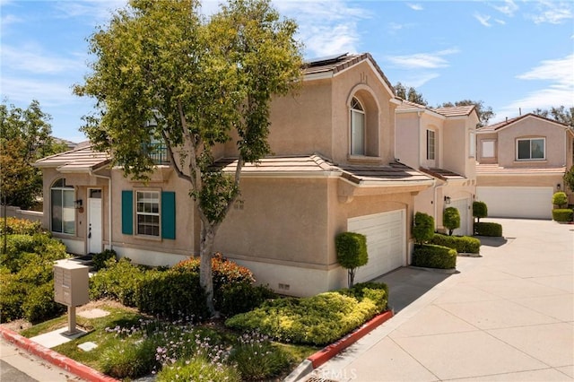 27861 Crown Court Cir Unit 72, Valencia, CA 91354 - view of front of home featuring a garage, stucco siding, concrete driveway, and roof mounted solar panels