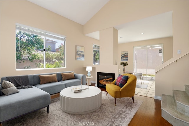 27861 Crown Court Cir Unit 72, Valencia, CA 91354 - living room featuring plenty of natural light, a glass covered fireplace, vaulted ceiling, hardwood / wood-style floors, and stairway