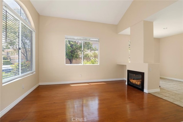 27861 Crown Court Cir Unit 72, Valencia, CA 91354 - unfurnished living room featuring plenty of natural light, a glass covered fireplace, and wood finished floors