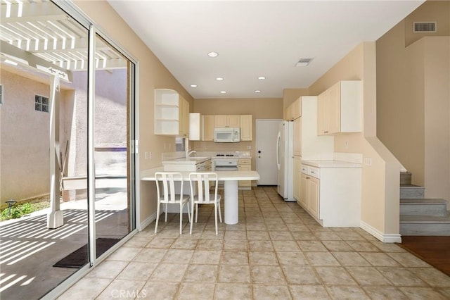 27861 Crown Court Cir Unit 72, Valencia, CA 91354 - kitchen featuring white appliances, light countertops, a peninsula, a kitchen breakfast bar, and recessed lighting