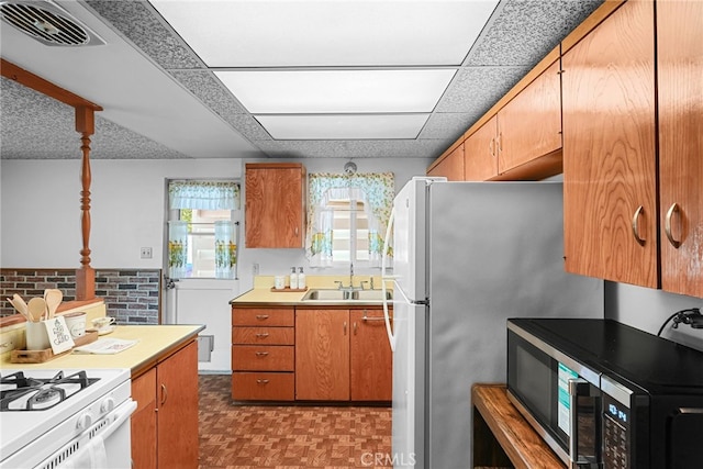 27439 Santa Clarita Rd, Saugus, CA 91350 - kitchen with white appliances, light countertops, and brown cabinetry