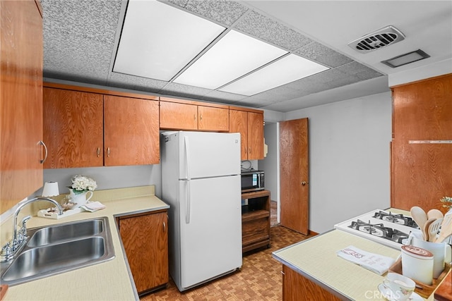 27439 Santa Clarita Rd, Saugus, CA 91350 - kitchen featuring freestanding refrigerator, stainless steel microwave, brown cabinets, and light countertops