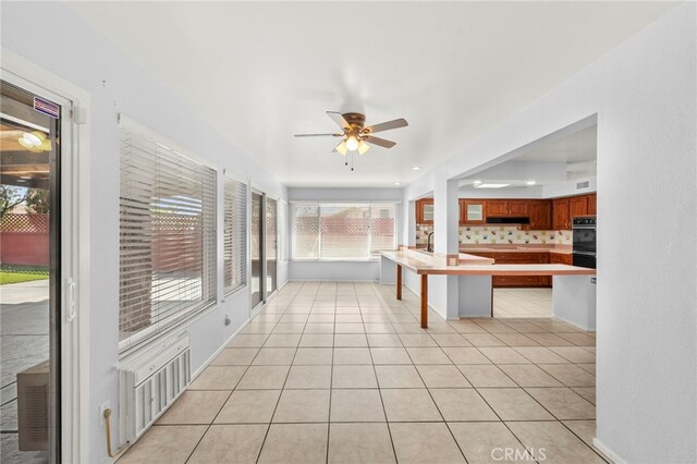 25925 Roanoke Rd, Menifee, CA 92586 - kitchen featuring a ceiling fan, a kitchen breakfast bar, a peninsula, light countertops, and light tile patterned floors