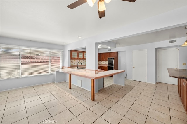 25925 Roanoke Rd, Menifee, CA 92586 - kitchen with a ceiling fan, light tile patterned flooring, a peninsula, brown cabinets, and recessed lighting