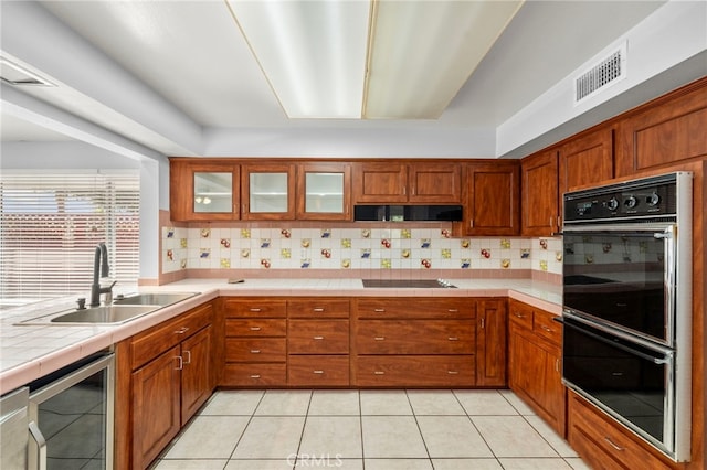 25925 Roanoke Rd, Menifee, CA 92586 - kitchen with black appliances, tasteful backsplash, brown cabinets, and tile counters