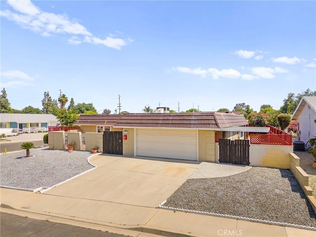 25925 Roanoke Rd, Menifee, CA 92586 - view of front of house with a fenced front yard, a gate, an attached garage, driveway, and mansard roof