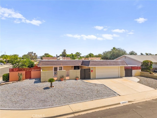 25925 Roanoke Rd, Menifee, CA 92586 - view of front of house with an attached garage, a fenced front yard, a gate, driveway, and a tiled roof