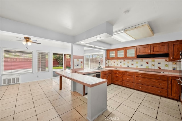 25925 Roanoke Rd, Menifee, CA 92586 - kitchen with a peninsula, tile counters, black electric cooktop, glass insert cabinets, and light tile patterned floors