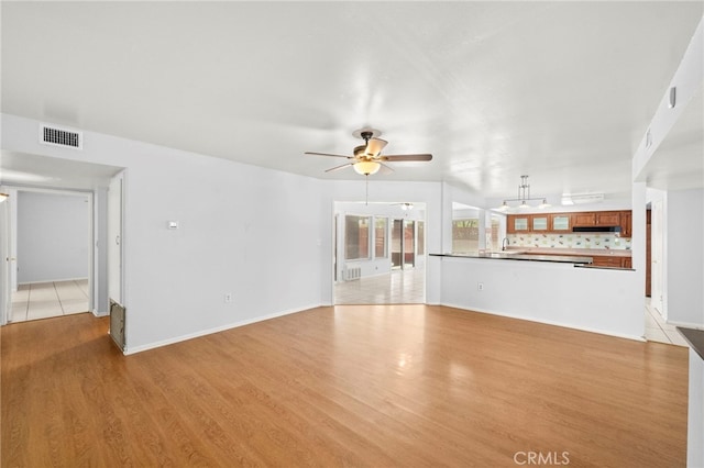 25925 Roanoke Rd, Menifee, CA 92586 - unfurnished living room with light wood-style flooring and ceiling fan