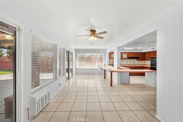25925 Roanoke Rd, Menifee, CA 92586 - kitchen with a ceiling fan, a peninsula, a breakfast bar, light countertops, and light tile patterned flooring