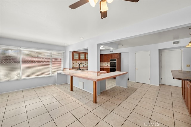 25925 Roanoke Rd, Menifee, CA 92586 - kitchen with a ceiling fan, light tile patterned flooring, a peninsula, brown cabinets, and recessed lighting