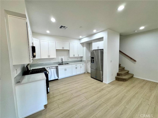 13105 Via Tuscany, Riverside, CA 92503 - kitchen with appliances with stainless steel finishes, light wood-style floors, white cabinets, light countertops, and recessed lighting